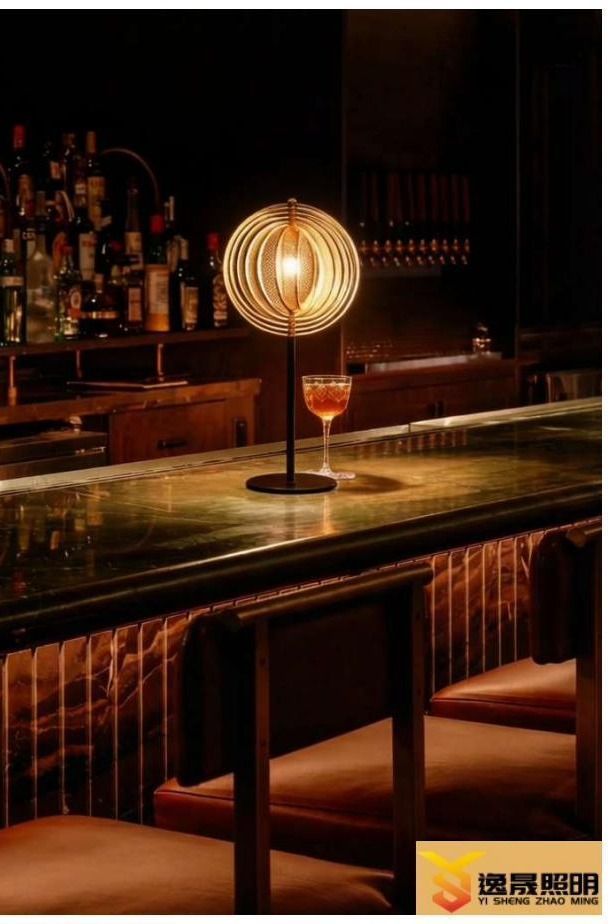 Spiral ring table lamp glowing on a bar counter