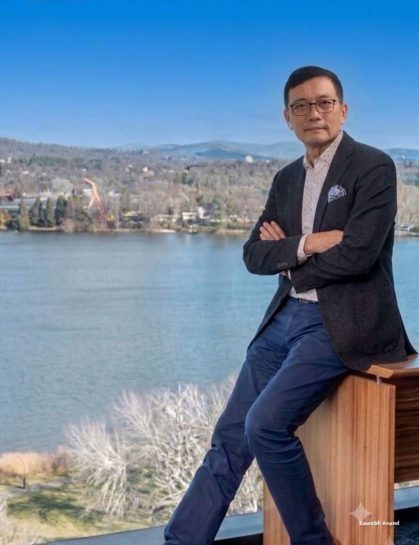David Hsu, founder and General Manager of Lean Co., Limited, standing on a balcony overlooking a lake